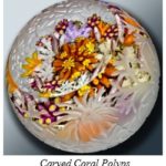Glass paperweight with coral polyps in fall-like colors. Outside glass carving enhances the coral scene